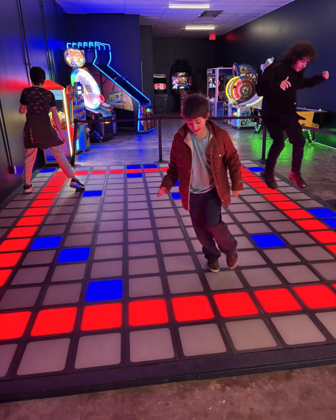 Youth playing on the pixel gaming floor.